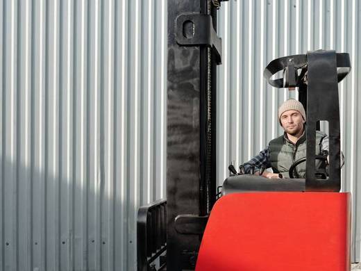 Operator na wózku wysokiego składowania czeka na kolejne zlecenie.